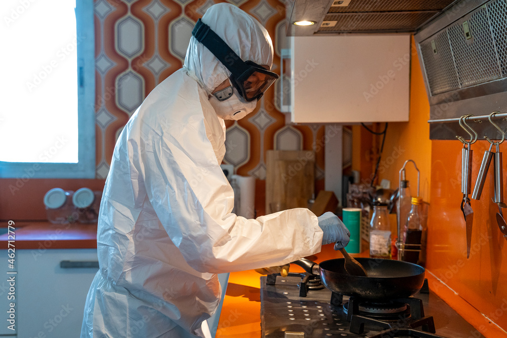 Woman wearing protective clothes, cooking in kitchen